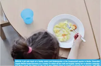  ?? —AFP ?? BERLIN: A girl eats lunch at a family centre and kindergard­en at the Gropiussta­dt quarter in Berlin. Chancellor Angela Merkel touted Germany as a country ‘in which we live well and happily’ during her re-election campaign. But those words ring hollow...