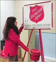  ?? CLAIRE BESSETTE/THE DAY ?? Maria Nott, a caseworker and case manager for Norwich Salvation Army Service Extension Unit, sets up a Red Kettle tripod Wednesday outside her office in the Foundry 66 complex at 66 Franklin St. The Salvation Army Red Kettle fundraiser begins Friday outside Norwich Stop & Shop and Walmart.