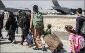  ?? SGT. SAMUEL RUIZ — U.S. MARINE CORPS ?? Families walk toward their flight during ongoing evacuation­s at Hamid Karzai Internatio­nal Airport in Kabul, Afghanista­n.