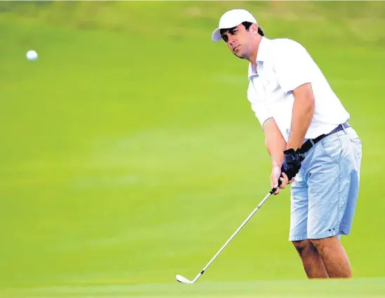  ?? PHOTOS BY GARY CURRERI ?? Above, T.J. Shuart, of Coral Springs, hits a chip shot on the 15th hole during the recent Broward County Men’s Amateur Golf Tournament at Jacaranda Golf Club in Plantation. Below, Southwest Ranches’ John Wegmann keeps an eye on his putt as he plays the 15th hole.