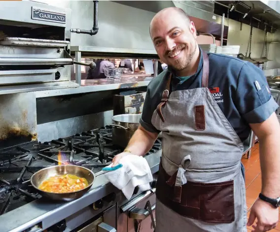  ??  ?? Executive chef Terry Salmond prepares a roasted garlic and walnut dip in his kitchen at Kitchener’s Charcoal Steakhouse. You can make this treat, too. See page 152.