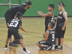  ??  ?? DIALOGO A MITAD de partido entre el entrenador y jugadores del equipo Little Ballerz y en el primer día de acción de la liga juvenil de basquetbol.