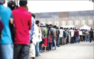  ?? PEDRO PARDO/AFP ?? Central American migrants, mostly from Honduras, wanting to reach the US in hope of a better life, line up for food outside a shelter in Tijuana, Baja California State, Mexico, near the US-Mexico border fence.