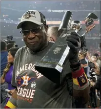  ?? TONY GUTIERREZ — THE ASSOCIATED PRESS ?? Houston manager Dusty Baker holds the American League championsh­ip trophy after the Astros beat Boston on Friday.