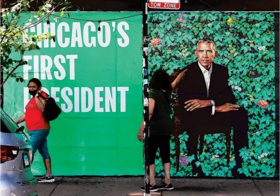  ?? JOHN J. KIM/CHICAGO TRIBUNE ?? A woman points to an advertisem­ent for “The Obama Portraits” on a wall of a business in the 1500 block of North Damen Avenue on June 8.