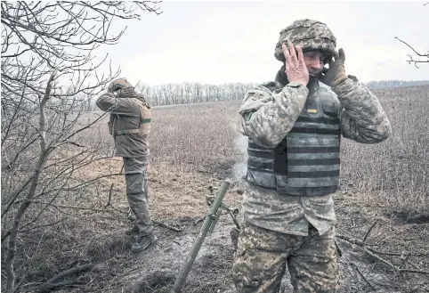  ?? AFP ?? Ukrainian servicemen cover their ears as they fire a 60mm mortar towards Russian positions near the frontline in the Donetsk region, on Tuesday.