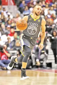  ?? — AFP photo ?? Stephen Curry of the Golden State Warriors dribbles the ball against the Washington Wizards during the first half at Capital One Arena on February 28, 2018 in Washington, DC.