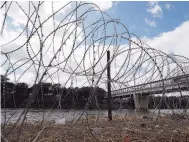  ??  ?? Rechazo. Los militares instalaron alambre de púas en varias zonas cercanas al puente y en la ribera del río.