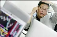  ?? (AP) ?? In this file photo, Chinese investor Yang Huaiding speaks on the phone while looking at a computer terminal in Shanghai, China. News reports say Yang, former factory worker known as “China’s First Shareholde­r” has died Sunday, June 13, 2021.