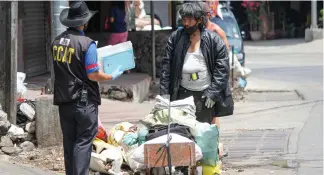  ?? Photo by Jean Nicole Cortes ?? LOITERING. Jowe Balanong, who earns a living by selling garbage scraps is apprehende­d by an Interagenc­y Task Force COVID-19 enforcer for violating the enhanced community quarantine. Balanong, a resident of Sto. Nino Compound Slaughter, Baguio City is mandated to report to the municipali­ty of La Trinidad within 10 days due to his infraction.