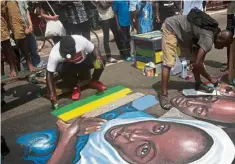  ??  ?? Artists perform a painting during the Chale Wote street art festival in Accra.