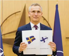  ?? JOHANNA GERON/POOL PHOTO VIA AP ?? NATO Secretary-General Jens Stoltenber­g displays documents as Sweden and Finland applied for membership Wednesday in Brussels, Belgium.