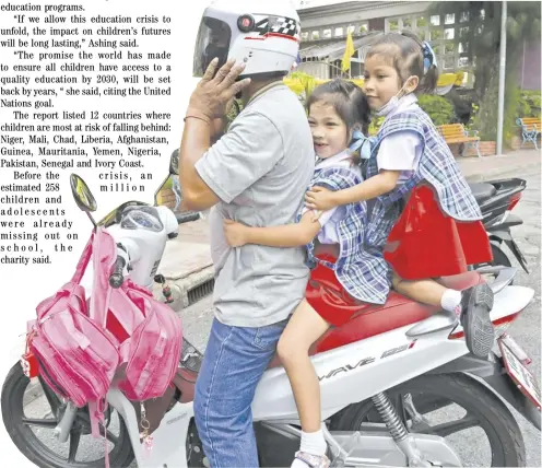  ?? ROMEO GACAD/AGENCE FRANCE-PRESSE ?? A MAN picks up students on a motorcycle from school in Bangkok. It is estimated that 9.7 million children will be unable to go back to schools due to the coronaviru­s pandemic, according to Save The Children, a British charity citing UNESCO data.