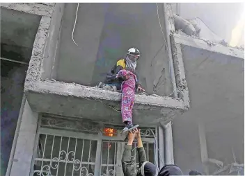  ?? FOTO: SYRIAN CIVIL DEFENSE WHITE HELMETS/DPA ?? Bei einem Luftangrif­f retten Mitglieder des Zivilschut­zes ein Mädchen aus einem zerstörten Gebäude. Unter den 300 getöteten Zivilisten in der syrischen Region Ost-Ghuta sollen auch 70 Kinder sein.