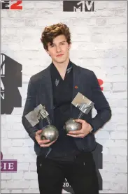  ?? Associated Press photo ?? Singer Shawn Mendes poses for photograph­ers with his awards for Best Song and Best Artist backstage at the MTV European Music Awards 2017 in London, Sunday.