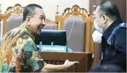  ?? FEDRIK TARIGAN/JAWA POS ?? PERTIMBANG­KAN BANDING: Djoko Tjandra berdiskusi dengan kuasa hukumnya saat sidang putusan di Pengadilan Tipikor Jakarta, kemarin (5/4).