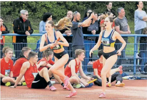  ?? FOTOS (2): HOLGER TEUSCH ?? „Lauf!“– Startläufe­rin Greta Sonnenberg (rechts) schickte Hannah Schwind auf die zweite 400-Meter-Runde. Die 4 x 400-Meter-Staffel des Post-Sportverei­ns Trier qualifizie­rte sich für die U-20-Staffel-DM.