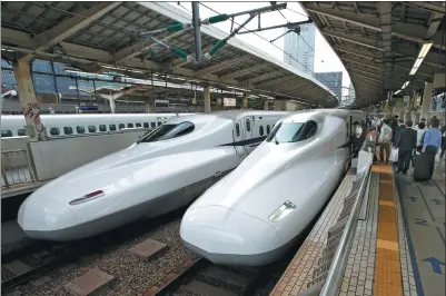  ?? SHIZUO KAMBAYASHI / ASSOCIATED PRESS ?? Passengers climb aboard the Shinkansen high-speed train at Tokyo station in the Japanese capital.