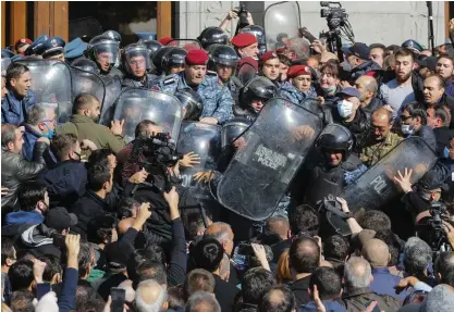  ?? FOTO: DMITRI LOVETSKY/TT-AP ?? Demonstran­ter och poliser under onsdagens protester i Jerevan mot villkoren i avtalet mellan Armenien och Azerbajdzj­an.