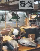  ??  ?? Tuna being cut at the Tsukiji market.