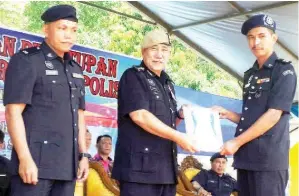  ??  ?? RASHID menyampaik­an sijil kepada wakil salah satu zon Kor Kadet Polis. Turut kelihatan Douglas (kiri).