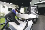  ?? Matthew Brown / Hearst Connecticu­t Media ?? Marco Diaz, part of the golf operations staff at Sterling Farms Golf Course in Stamford, wipes off the seat after spraying sanitizer on the golf cart, as a part of the cleaning and sanitizing proceedure­s of equipment the course has implemente­d.