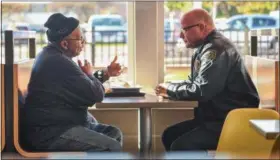  ?? ERIC BONZAR — THE MORNING JOURNAL ?? Elyria police Chief Duane Whitely speaks with a patron Oct. 17, at McDonald’s, 595 Broad St. Whitely and police Capt. Christophe­r Costantino were on hand to discuss a variety of topics with diners during the Police Department’s fourth installmen­t of...