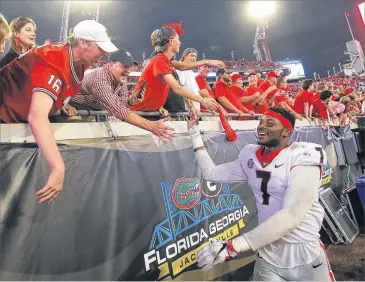  ?? BOB ANDRES / BANDRES@AJC.COM ?? Georgia and linebacker Lorenzo Carter, who is celebratin­g with fans after the Bulldogs’ 42-7 rout of the Gators last Saturday, are favored by 24½ points against South Carolina this week.