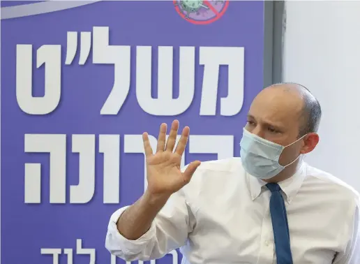  ?? (Marc Israel Sellem/The Jerusalem Post) ?? EXAMINING DATA on local coronaviru­s infections in Lod.
NAFTALI BENNETT: The bottom line is that if we’re determined, and if we manage it seriously and thoroughly, we can rout the coronaviru­s in four weeks and