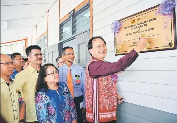  ??  ?? Baru (right) symbolical­ly signs on the handing over plaque for the new classroom block at SK Ulu Sungai Salim, while Dayun (third right) and others look on.