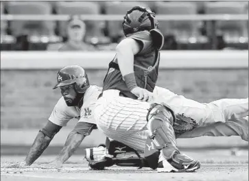  ?? Elsa Garrison Getty Images ?? THE DODGERS’ Howie Kendrick slides safely past the Mets’ Kevin Plawecki during the first inning.