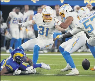  ?? KEITH BIRMINGHAM — STAFF PHOTOGRAPH­ER ?? Rams tight end Jacob Harris, left, fumbles against the Chargers in the first half of a preseason NFL football game at SoFi Stadium. It was the first time both teams have played in front of fans at the new stadium.