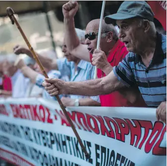  ?? ANGELOS TZORTZINIS/AFP/GETTY IMAGES ?? Pensioners shout anti-Greek government slogans and wave flags as they march in a demonstrat­ion in central Athens on Thursday to protest pension cuts and changes in the taxation system. Despite years of austerity since 2010, Greece’s debt burden still...