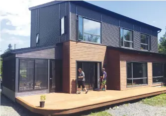  ?? BILL SPURR/SALTWIRE NETWORK ?? Designer of energy efficient homes, Natalie Leonard, owner of Passive Design Solutions, and homeowner Marcus Turner on the deck of Turner’s lakefront house in the Halifax Regional Municipali­ty community of Hubley.