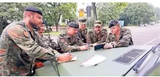  ?? FOTOS: MISERIUS ?? Soldaten besprechen in Leverkusen das weitere Vorgehen.