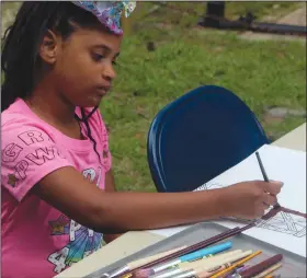  ??  ?? Painting: Milani James, age 7, paints a picture of a 1920s oil derrick during the National Kids to Park Day on Saturday at the Arkansas Museum of Natural Resources in Smackover.