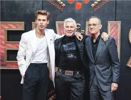  ?? PHOTO BY VIANNEY LE CAER/INVISION/AP ?? From left, Austin Butler, director Baz Luhrmann, and Tom Hanks pose for photograph­ers upon arrival for the premiere of the film ‘Elvis’ on Tuesday in London.