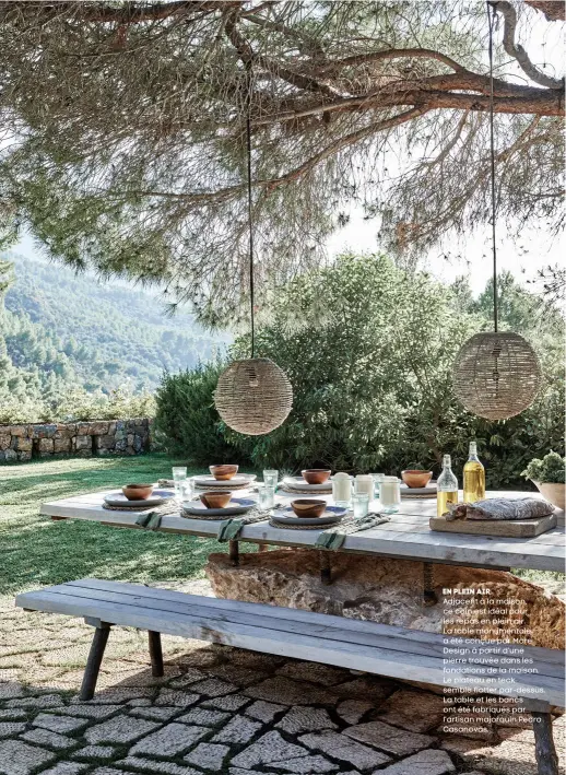  ??  ?? en plein air Adjacent à la maison, ce coin est idéal pour les repas en plein air. La table monumental­e a été conçue par More Design à partir d’une pierre trouvée dans les fondations de la maison. Le plateau en teck semble flotter par-dessus. La table et les bancs ont été fabriqués par l’artisan majorquin Pedro Casanovas.