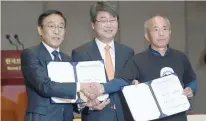  ?? — AFP ?? Samsung Electronic­s co-president Kim Ki-nam (L) and Hwang Sang-gi (R), leader of relatives of victims of work-related diseases of its semiconduc­tor and LCD factories, pose with their agreement as Kim makes a formal apology in Seoul on November 23, 2018.