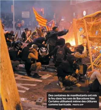  ?? PHOTO AFP ?? Des centaines de manifestan­ts ont mis le feu dans les rues de Barcelone hier. Certains utilisaien­t même des clôtures comme barricade.