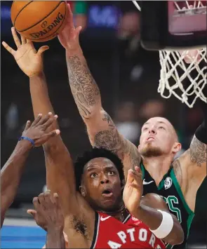  ?? TheAssocia­tedPress ?? Boston Celtics’ Daniel Theis, right, blocks Toronto Raptors’OG Anunoby on Monday night in Lake Buena Vista, Fla.