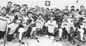  ?? [AP PHOTO] ?? South Korean President Moon Jae-in, center top, poses with South Korean women’s and men’s ice hockey team players during a visit to Jincheon National Training Center in Jincheon, South Korea, on Wednesday. South Korea and North Korea will field a joint...