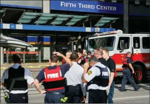  ?? AP/JOHN MINCHILLO ?? Cincinnati emergency personnel work Thursday outside the 30-story Fifth Third Bancorp building, where a gunman opened fire, killing three people before officers killed him.