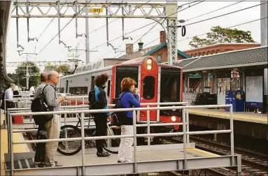  ?? Brian A. Pounds / Hearst Connecticu­t Media ?? Passengers prepare to board a New York-bound Metro-North train at the Milford train station. United Illuminati­ng will rebuild its transmissi­on lines and separate them from the Metro-North power lines starting in 2023.