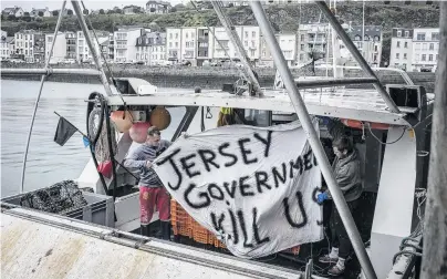  ?? PHOTO: GETTY IMAGES ?? Feelings run high . . . French fishermen just returned from sea protesting with a fleet of fishing boats in the territoria­l waters of Jersey yesterday show a banner that reads ‘‘Jersey government kill us’’ in Granville, France.