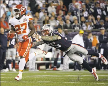  ?? STEVEN SENNE — ASSOCIATED PRESS ?? Chiefs running back Kareem Hunt eludes Patriots defensive end Cassius Marsh as he runs for one of his three touchdowns in a 42-27 upset over the defending Super Bowl champions on Thursday in the first game of the NFL season.