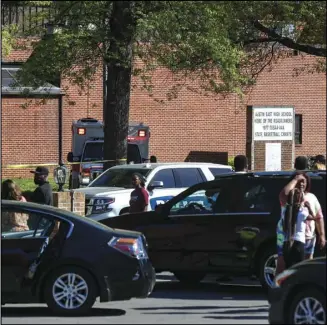  ?? ASSOCIATED PRESS ?? People gather outside Austin East High School in Knoxville, Tenn., as Knoxville police work the scene following a shooting at the school Monday.