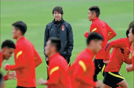  ?? XINHUA ?? Team China head coach Li Tie keeps a watchful eye on his players during a training session in Shanghai on Sunday.