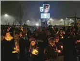  ?? JOSHUA BESSEX/AP ?? Bills fans and community members gather for a candleligh­t vigil for Bills safety Damar Hamlin on Tuesday in Orchard Park, N.Y.