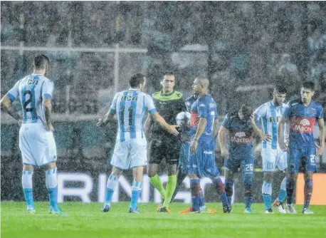  ?? TÉLAM ?? Carlos Luna y Luciano Aued se resignan ante la decisión del árbitro Pedro Argañaraz. La lluvia obligó a la suspensión.